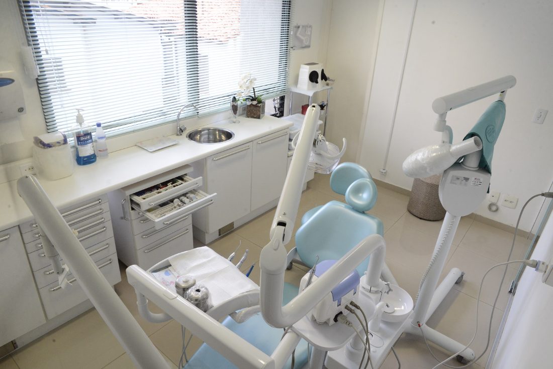 Equipamento odontológico e refletor na sala de atendimento